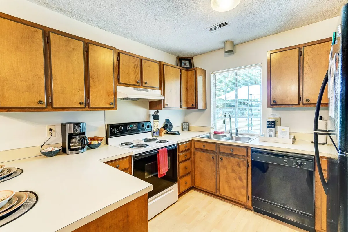 A bright, functional kitchen space featuring ample countertops, modern appliances, and a window with a pleasant view. The layout encourages cooking and gathering, ideal for preparing meals and socializing.