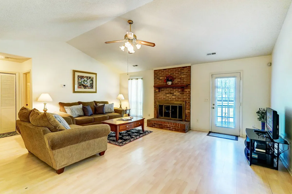 A cozy, contemporary living room with a sofa, fireplace, TV, and dining table, inviting families to relax, play games, or enjoy a movie night together. The warm, comfortable atmosphere is perfect for unwinding after a day of outdoor fun.